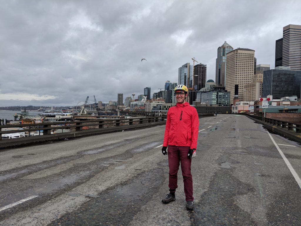 Damien Dabrowski in a bike helmet and raincoat on the Alaskan Way viaduct.